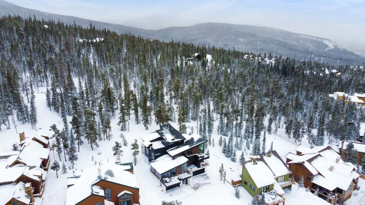 Aerial view of this stunning townhome surrounded by lush snowcapped trees