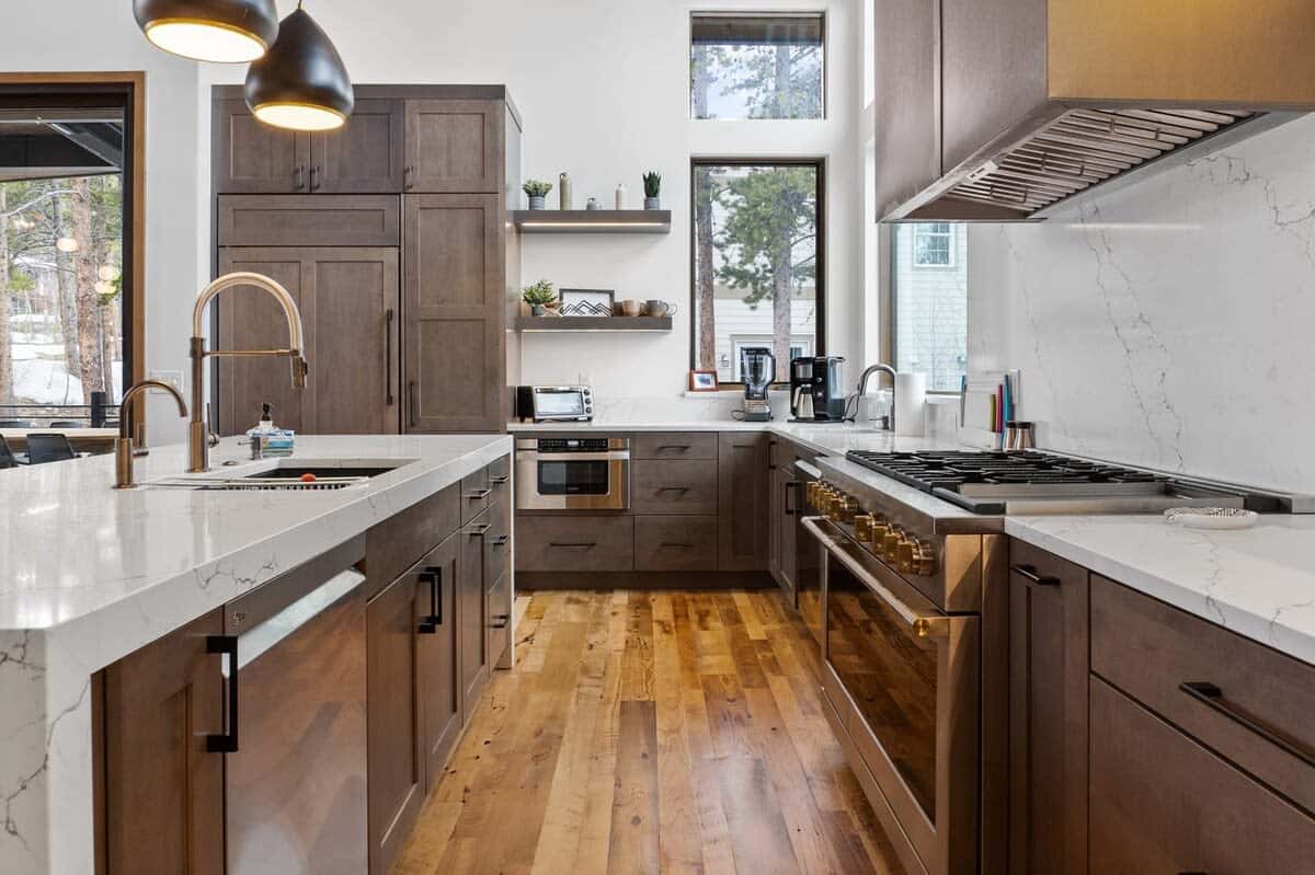 The stylish kitchen is perfect for cooking for a crowd with large marble countertops, luxury grade appliances, two dishwashers, and a large kitchen island.
