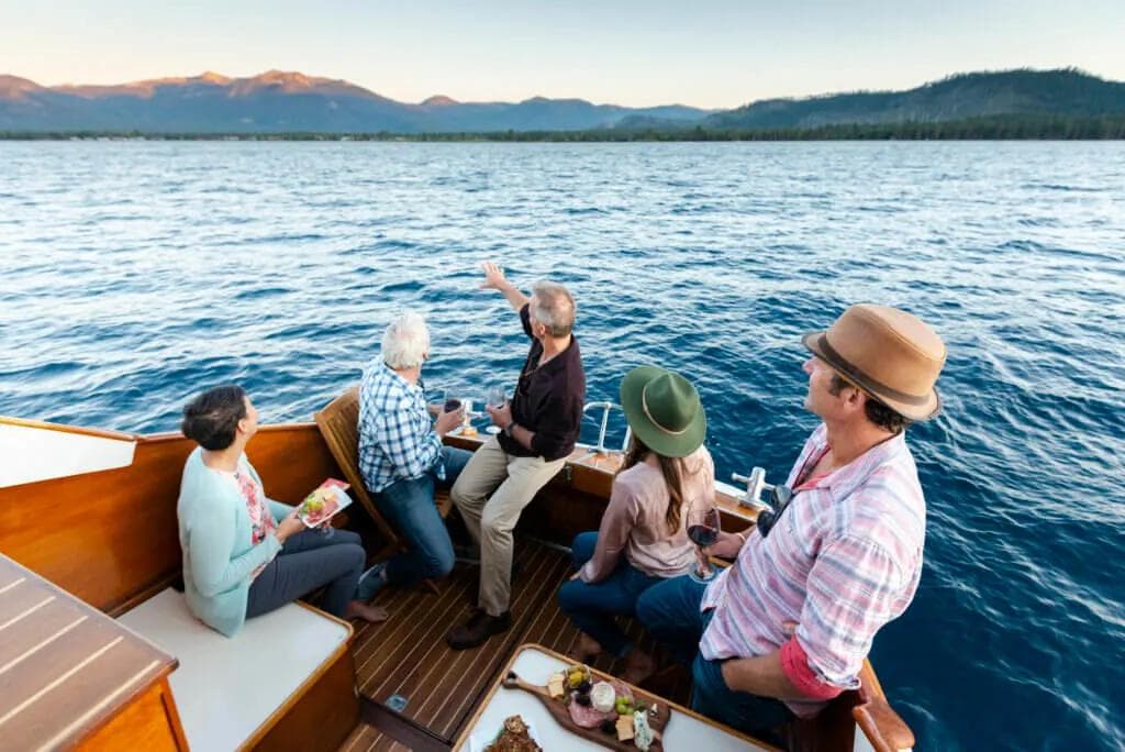 Family enjoying charcuterie on a lake with a mountain view